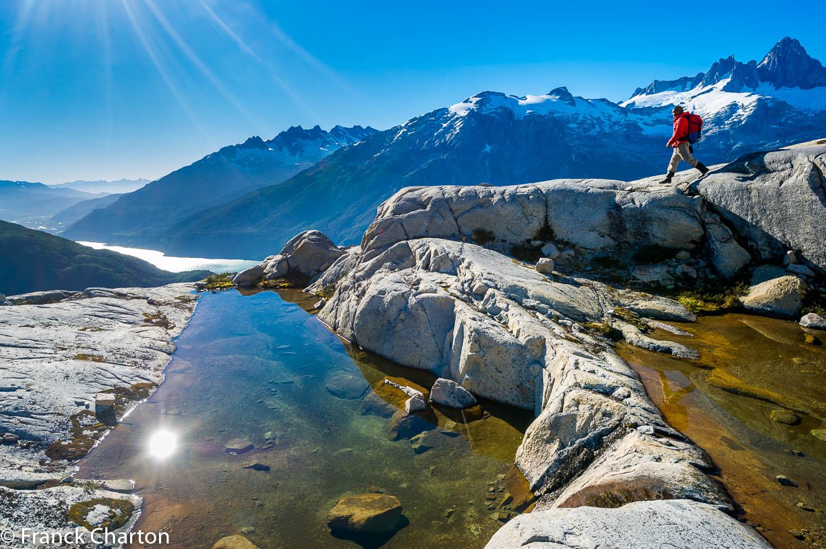 Le guide patagon Ocho redescend les gradins rocheux encadrant le glacier « Putagonia », avec en contrebas le lago Leones aux allures de fjord. 