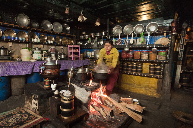 Une Népalaise prépare un repas pour des trekkeurs