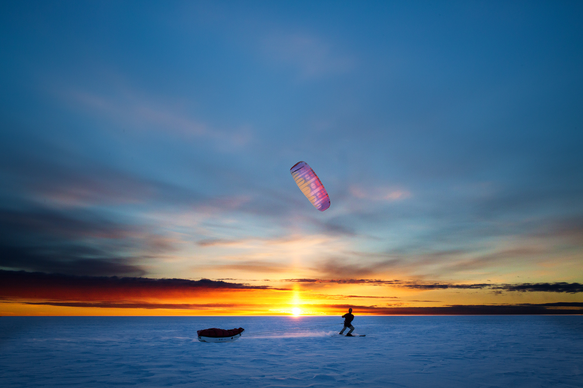 Snowkiter en Antarctique au soleil couchant