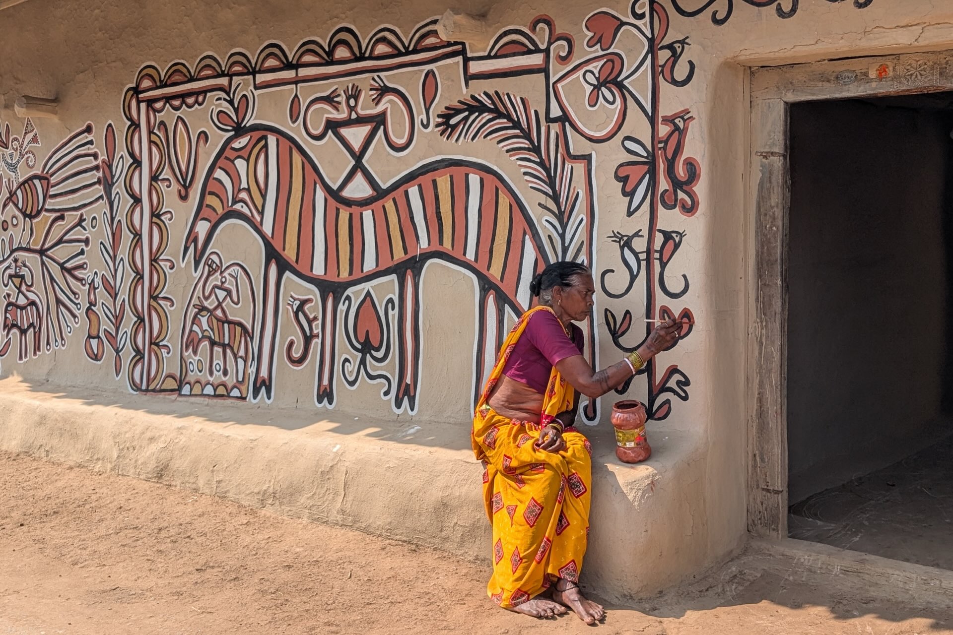 Une femme réalise une peinture sorhai sur le mur de sa main