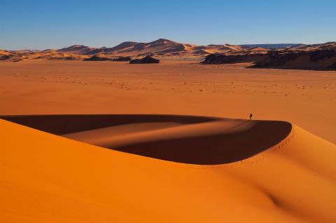 Trek dans un paysage de dunes rouges en Algérie