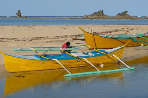 Trekking vers une pirogue à balancier sur la côte Pacifique au sud de l'île de Luzon