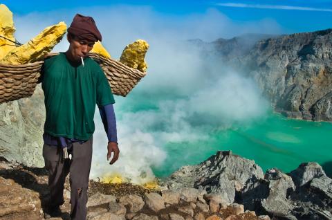 Randonnée avec un porteur de soufre au-dessus du lac d'acide du volcan Kawah Ijen