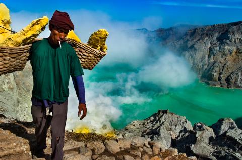 Randonnée avec un porteur de soufre au-dessus du lac d'acide du volcan Kawah Ijen