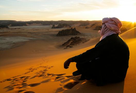 Trekking dans des dunes au soleil couchant dans la Tadrart en Algérie