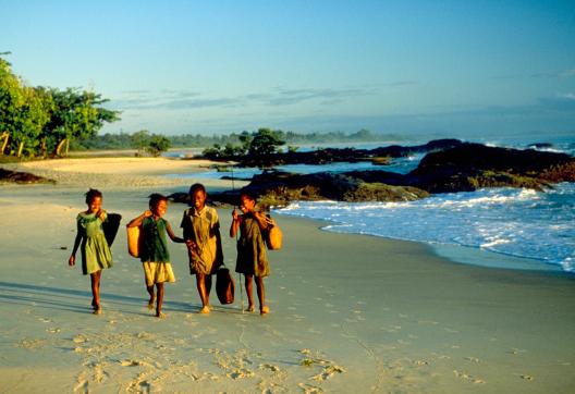 Marche avec les enfants au retour de l'école sur une plage de l'est de Madagascar