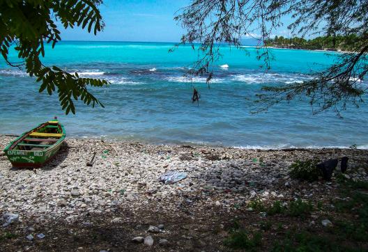 Balade vers une barque sur une plage de galets sur la côte haïtienne