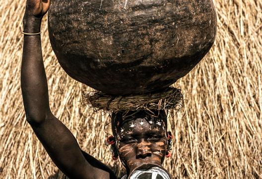 Marche vers une  porteuse de cruche en Pays Surma