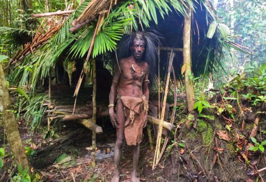 Trek vers un papou burati devant son abri de jungle près de la rivière Wapoga