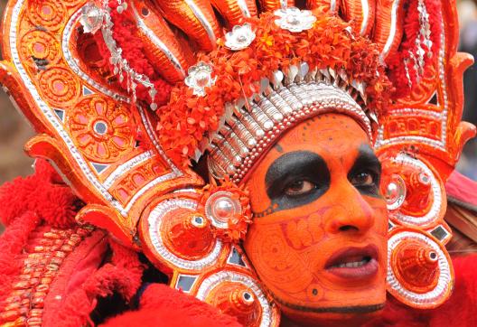 Randonnée vers un danseur grimé participant à un Theyyam dans la région de Kannur