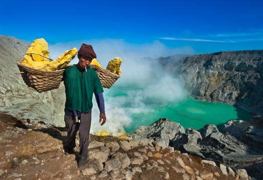 Randonnée avec un porteur de soufre au-dessus du lac d'acide du volcan Kawah Ijen