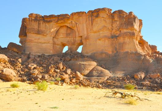 Trek le long d'une falaise avec des arches dans l'Ennedi