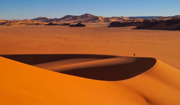 Trek dans un paysage de dunes rouges en Algérie