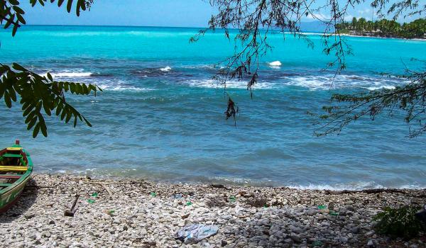 Balade vers une barque sur une plage de galets sur la côte haïtienne