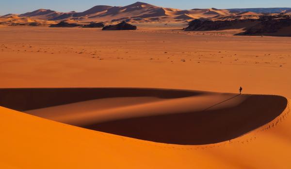 Trek dans un paysage de dunes rouges en Algérie