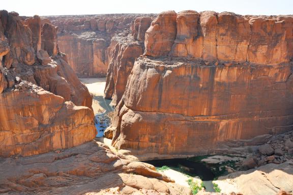 Trek dans un canyon rouge de l'Ennedi