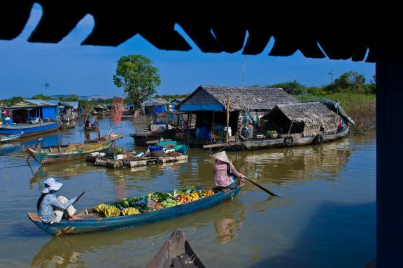 Navigation vers une pirogue-épicerie sur le lac Tonlé Sap à travers le village de Chong Khneas