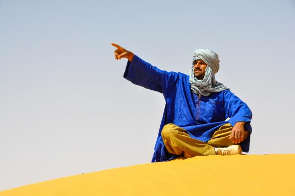 Voyage avec un guide Touareg assis dans l'Erg admer