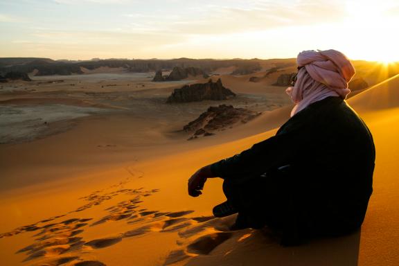 Trekking dans des dunes au soleil couchant dans la Tadrart en Algérie