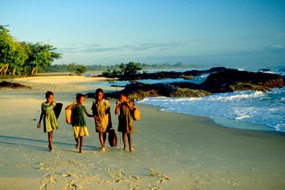 Marche avec les enfants au retour de l'école sur une plage de l'est de Madagascar