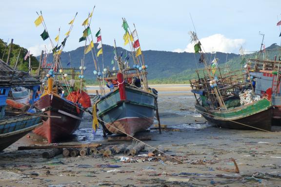 Trekking vers des bateaux de pêche au repos en bordure de la mer d'Andaman