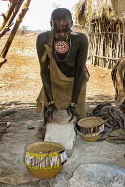 Randonnée vers une femme Mursi travaillant à la meule dans la Vallée de l'Omo