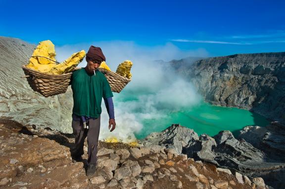 Randonnée avec un porteur de soufre au-dessus du lac d'acide du volcan Kawah Ijen