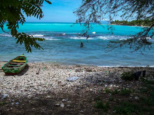 Balade vers une barque sur une plage de galets sur la côte haïtienne