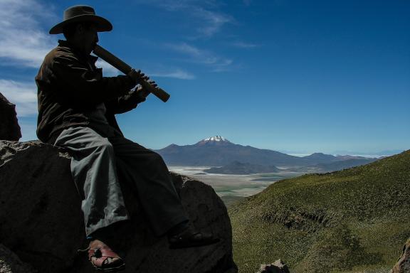 En face du Salar d'Uyuni, un indien Quechua joue un air de flûte en Bolivie