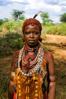 Randonnée avec une jeune Karo avec ses parures dans lae sud éthiopien