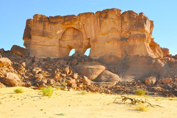 Trek le long d'une falaise avec des arches dans l'Ennedi