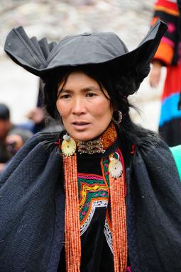 Trek vers une femme yi avec sa grande cape dans les Grandes Montagnes Froides