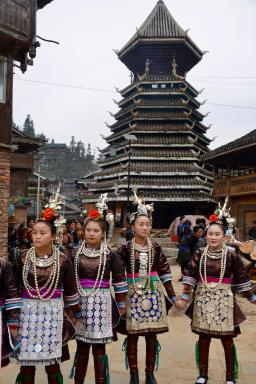 Randonnée vers des femmes dong devant une tour du tambour au Guizhou oriental