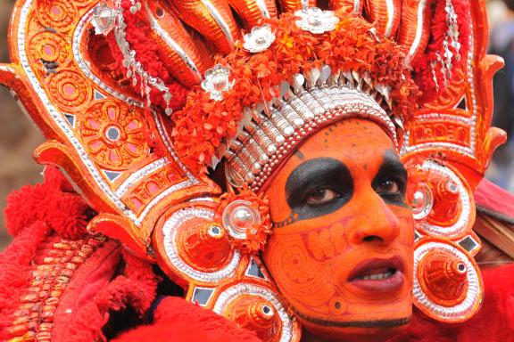 Randonnée vers un danseur grimé participant à un Theyyam dans la région de Kannur