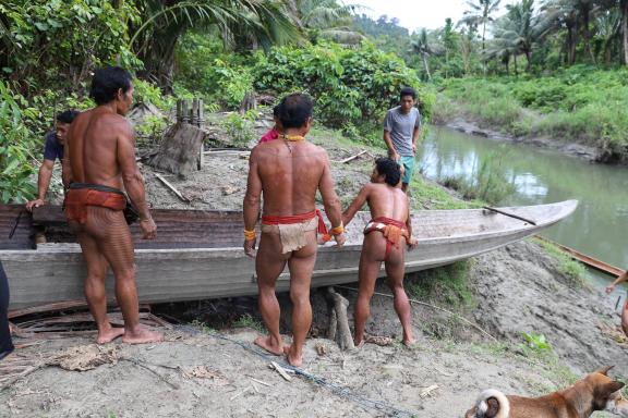 Trekking avec des Sakuddei qui tirent une pirogue vers la rivière sur l'île de Siberut