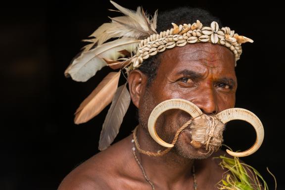 Trekking vers un homme paré pour une cérémonie sur vune île au large de la Nouvelle-Bretagne