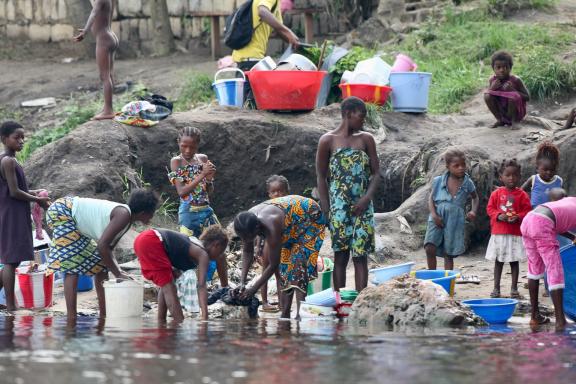 Femmes et enfants lavant le linge sur le bord du fleuve Congo en RD Congo