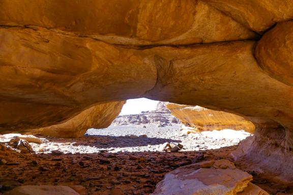 Trek sous une voûte rocheuse dans la Tadrart