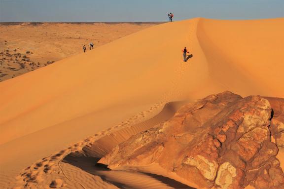 Trekking sur une montée d'une dune en Mauritanie