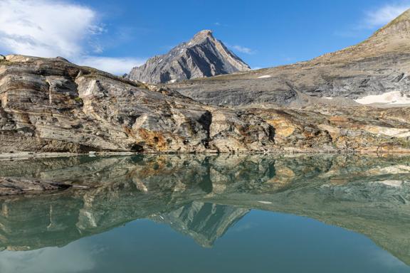 Trek et reflet d'un pic dans un lac de montagne en France