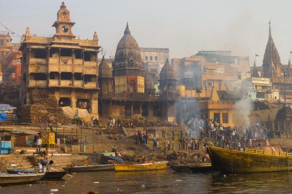 Navigation devant des crémations au bord du Gange à Varanasi