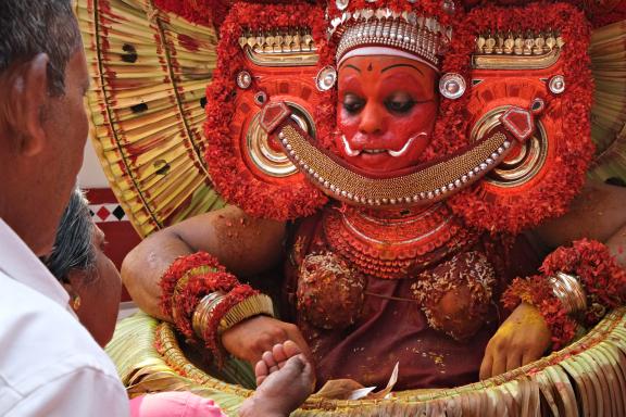 Approche d'une divinité incarnée lors d'une cérémonie de Theyyam au nord du Kerala